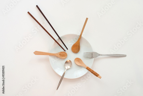 sharing concept - many wooden spoons, one silver spoon, chopsticks and a fork