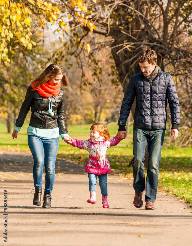 Fototapeta premium Happy young family walks in the park
