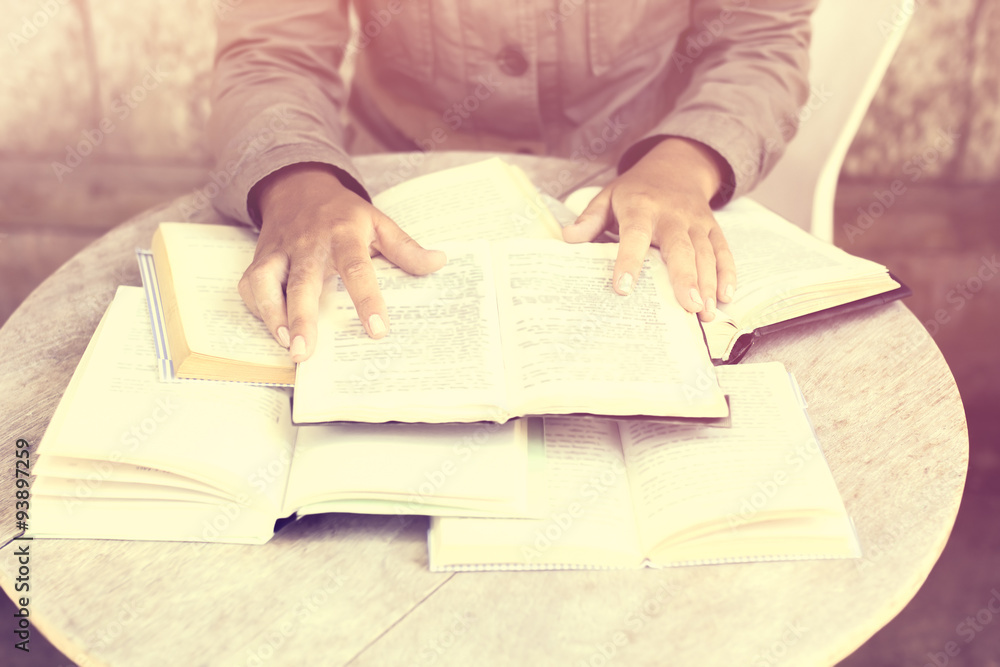 Girl and many open books on the table, vintage photo effect Girl and many open books on the table, vintage photo effect