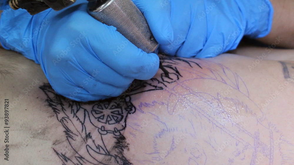 Tattoo master make tattoo a man in the tattoo parlor Tattoo master make tattoo a man in the tattoo parlor