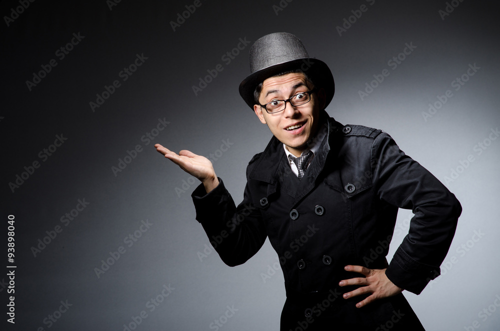 Young man in black coat and hat against gray Young man in black coat and hat against gray