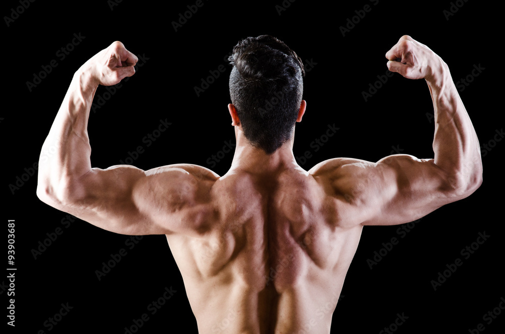 Muscular man posing in dark studio Muscular man posing in dark studio