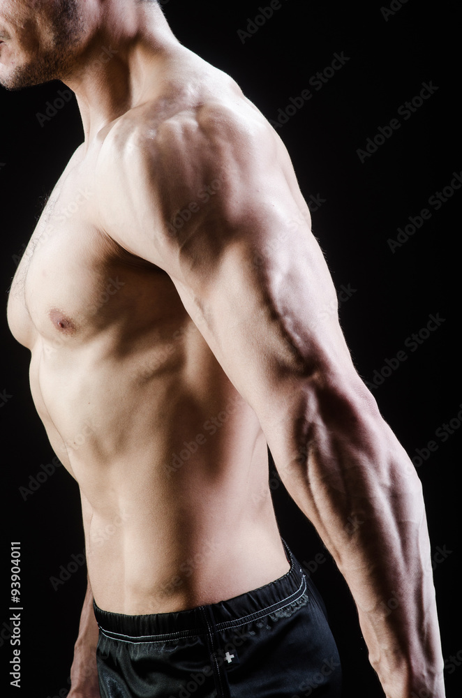 Muscular man posing in dark studio Muscular man posing in dark studio