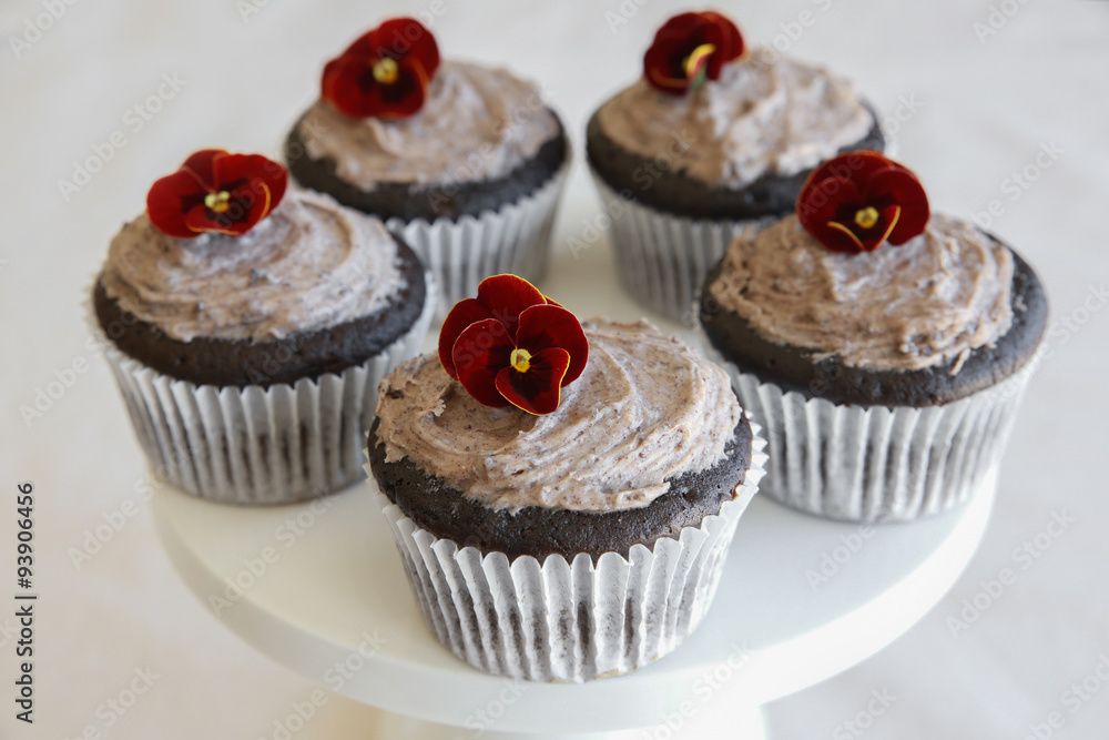 Homemade chocolate cupcakes with cookie and cream frosting and edible flower