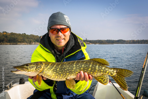 Happy angler with october's pike fishing trophy