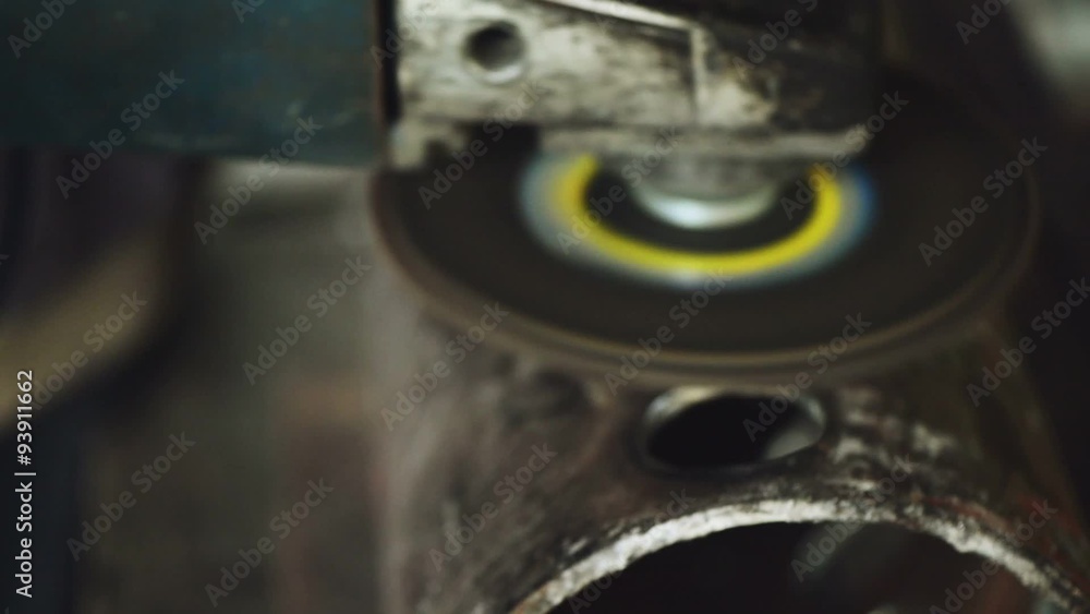 Metal worker grinding steel pipe, adult man using grinder to work on piece of metal in workshop, grinding sparks flying around, handheld camera with tracking focus Metal worker grinding steel pipe, adult man using grinder to work on piece of metal in workshop, grinding sparks flying around, handheld camera with tracking focus