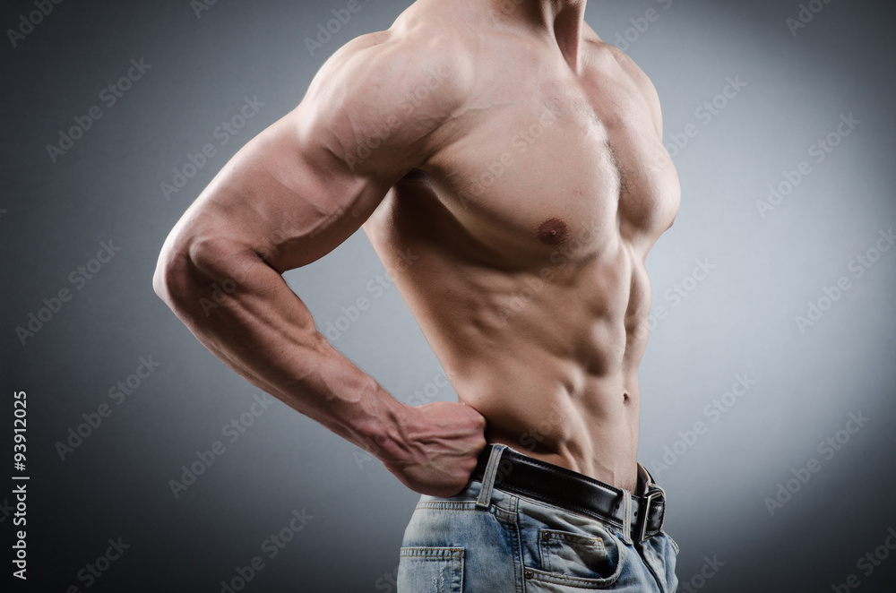 Fototapeta premium Muscular man posing in dark studio