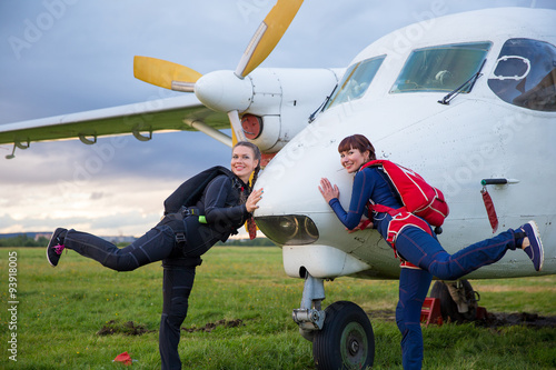 young women professional skydivers like white plane photo