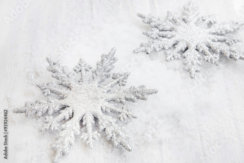 Two Silver Glittered Snowflakes Ornaments in the Snow
