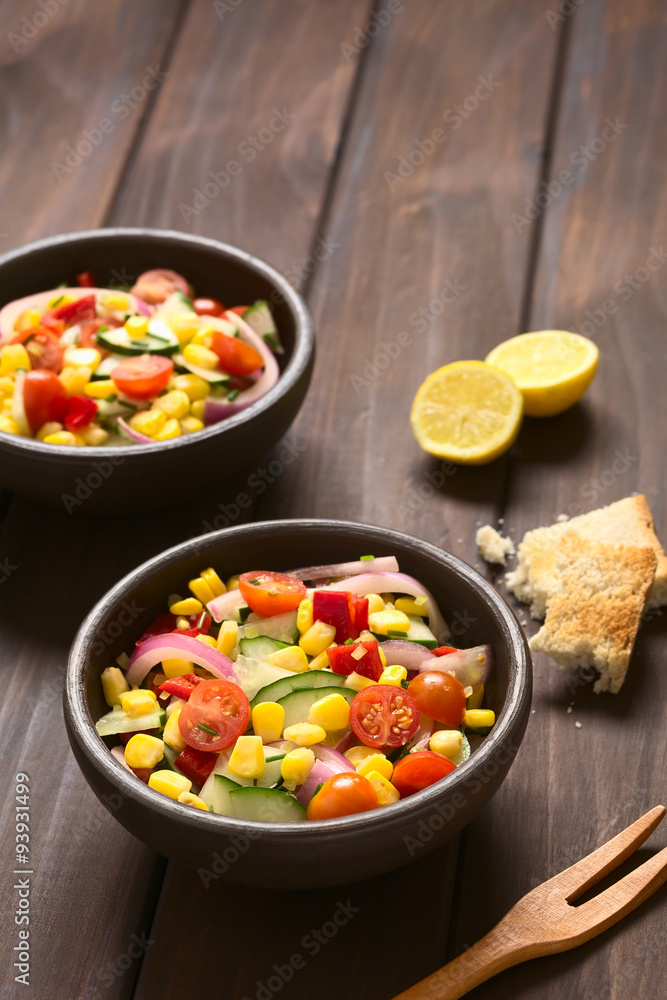Fresh vegetable salad made of sweet corn, cherry tomato, cucumber, red onion, red pepper, chives, photographed with natural light (Selective Focus, Focus one third into the first bowl) Fresh vegetable salad made of sweet corn, cherry tomato, cucumber, red onion, red pepper, chives, photographed with natural light (Selective Focus, Focus one third into the first bowl)