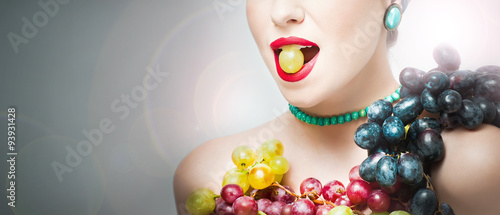 Beautiful creative makeup in fall concept, studio shot on gray background. Beauty fashion model girl with grapes arrangement