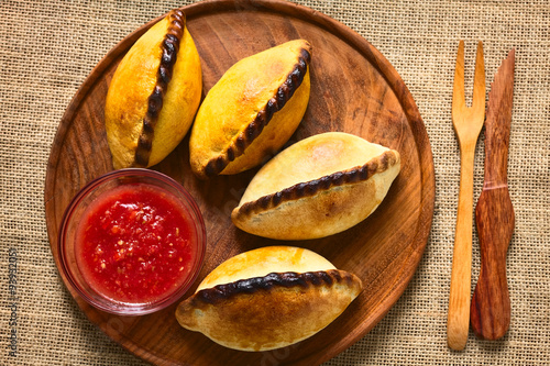 Overhead shot of traditional Bolivian savory pastries called Saltena filled with thick meat stew, which is a very popular street snack in Bolivia photographed with natural light photo