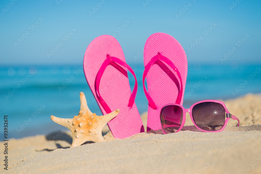 The sea, beach, sand and women's accessories: pink flip-flops, sunglasses  and starfish Stock Photo