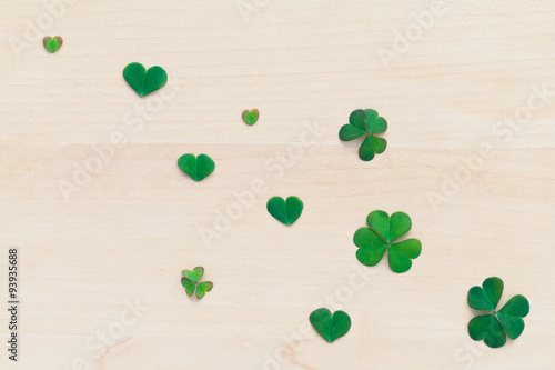 Closeup clovers leaves setup on wooden background.