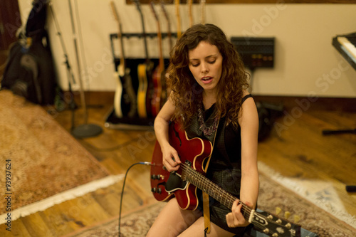 Young woman playing an electric guitar