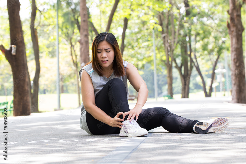 Sports injury. Woman with pain in ankle while jogging Sports injury. Woman with pain in ankle while jogging