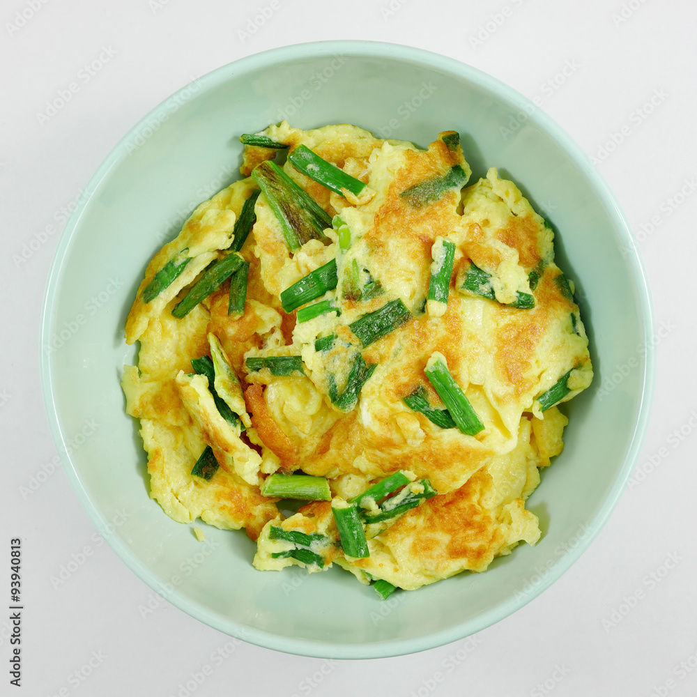 The homemade green onions omelet in green bowl. The homemade green onions omelet in green bowl.