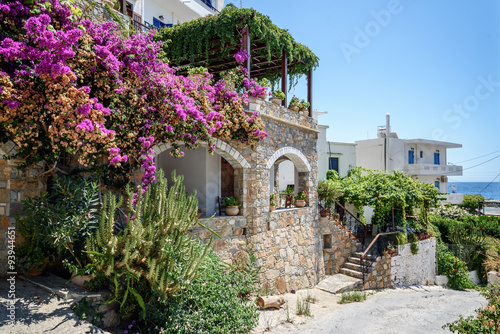 Traditional Greek stone house with bougainvillea flowers around it