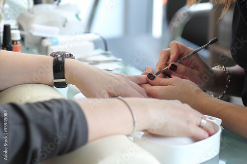 Woman in nail salon receiving manicure by beautician. Woman getting manicure at beauty salon 