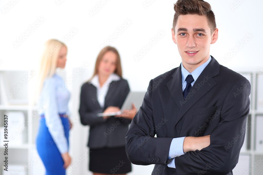 Cheerful business man in office with colleagues in the background, sturt-up team Cheerful business man in office with colleagues in the background, sturt-up team