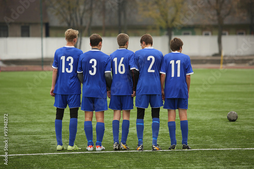 Row of football players wait kick