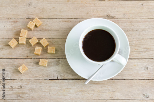 Tableau sur toile A cup of espresso with brown lump sugar around it, up view.