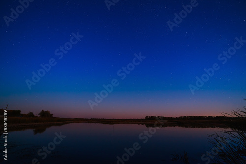 Smooth surface of the lake on a background the starry sky.