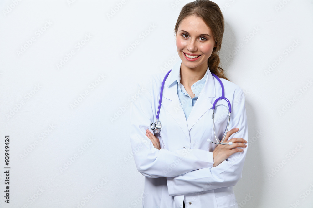 Friendly smiling young female doctor, standing near wall Friendly smiling young female doctor, standing near wall