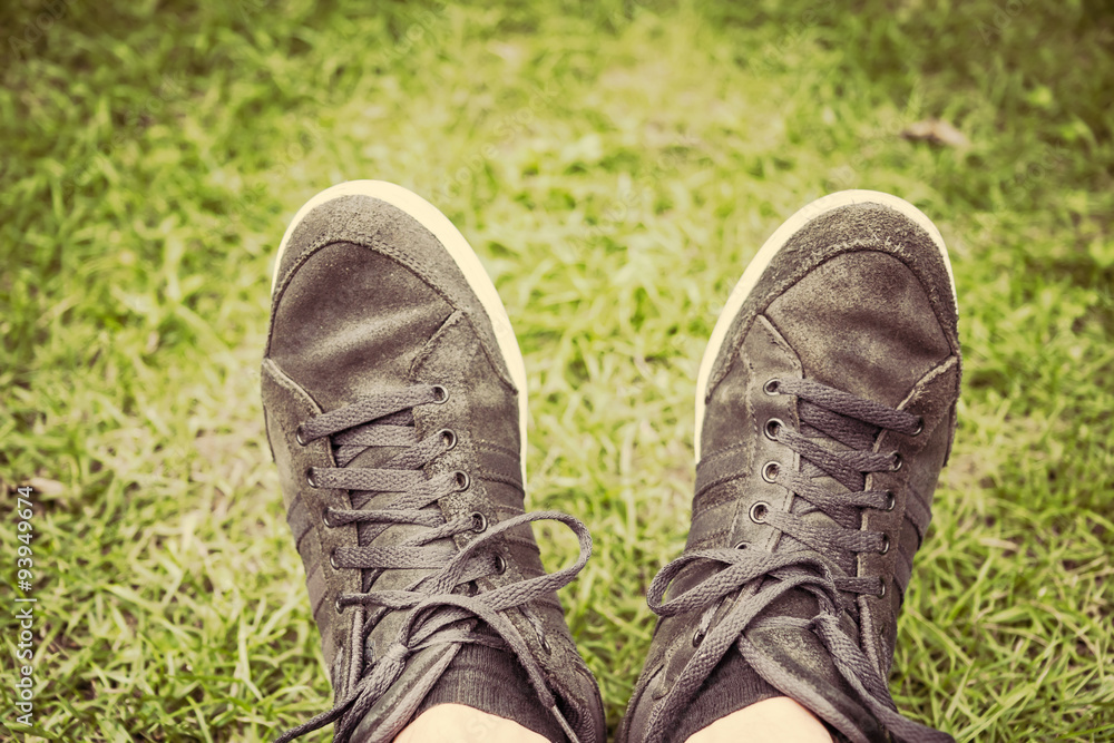 Tennager Feet in sneakers in the green grass