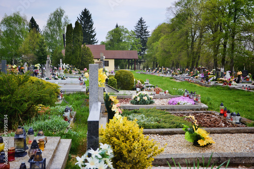 Graves / tombstones in the cemetery / graveyard. All Saints Day / All Hallows / 1st November. Flowers and candles on tomb stone in churchyard. Tvrdomestice/Prasice, Slovakia, Europe photo