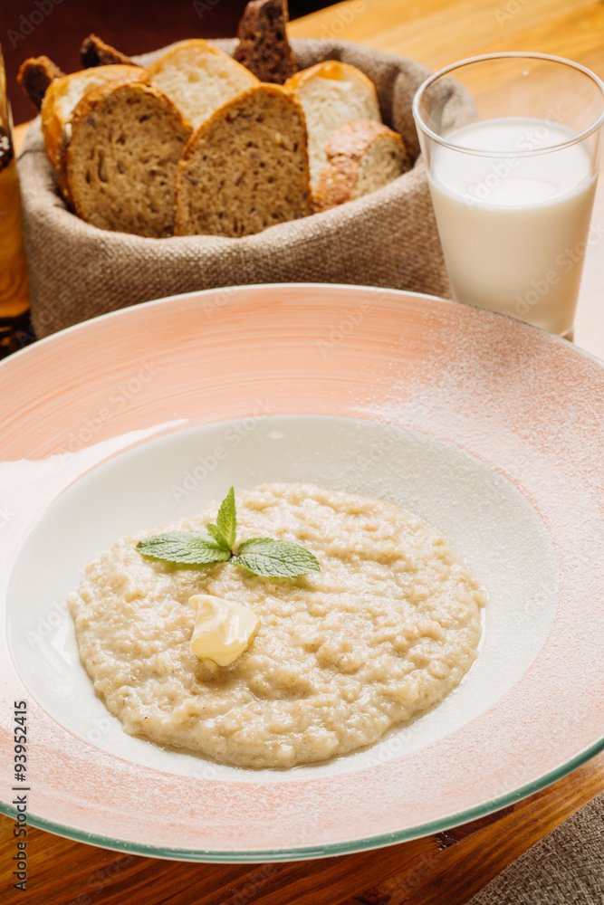 Oatmeal porridge with and glass of milk on wooden table
