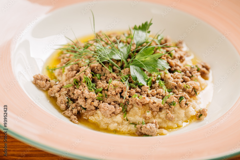 Oatmeal porridge with meat beef on wooden table Oatmeal porridge with meat beef on wooden table