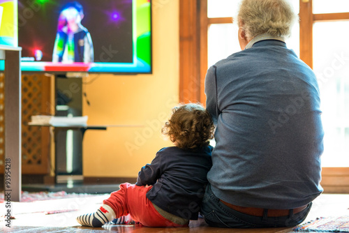 child and gradfather watching tv photo