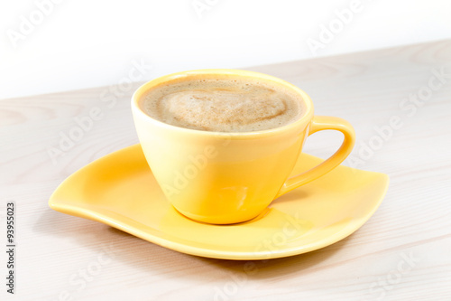 Yellow Cup of coffee on the table photo
