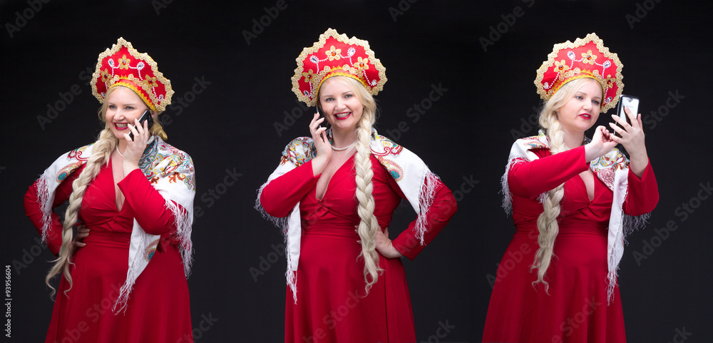 Girl standing in Russian traditional dress with mobile phone