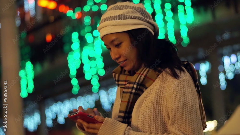 Video of Asian girl using smart phone during holiday season with christmas light background. Communication abstract Video of Asian girl using smart phone during holiday season with christmas light background. Communication abstract