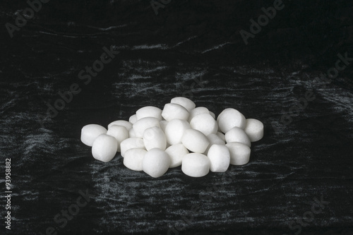 White naphthalene balls on black velvet