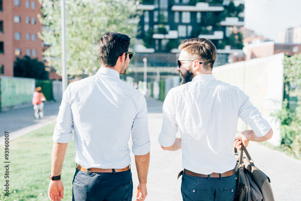 two modern businessman walking in the city