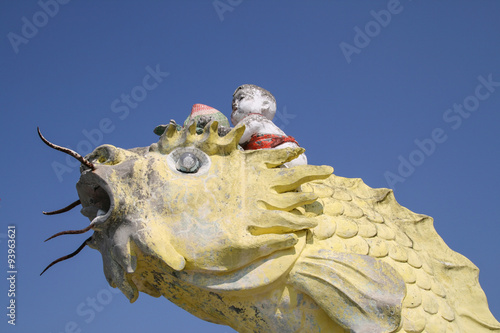 Chinese baby god  riding on a yellow fish traditional statue at Kwun Yam Shrine temple, Repulse Bay,  Hong Kong. photo