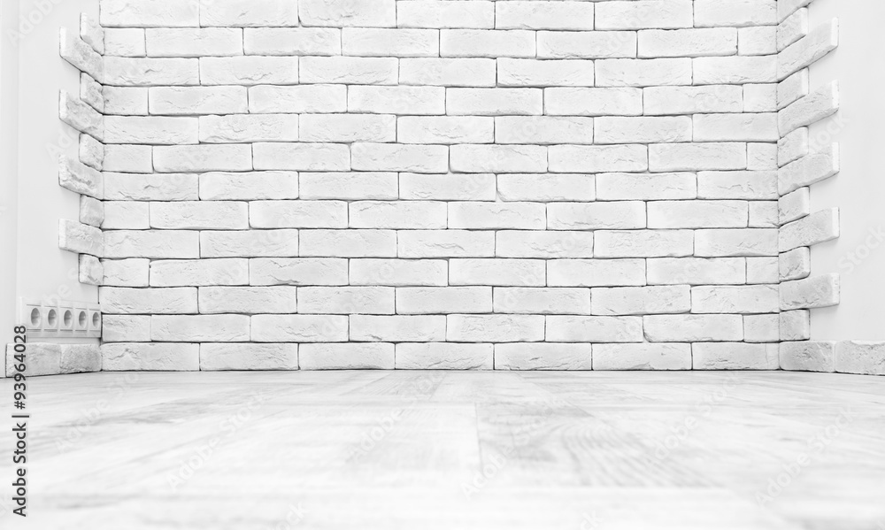 Fototapeta premium Brick wall in empty white studio room features light wood parquet floor and neutral interior architecture, creating a clean modern backdrop mockup for product placement