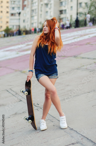 Redhead slim girl in jeans shorts and black t shirt.