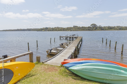 Colorful Canoes at the Jetty in the Blackwood River with Molloy Island on the Horizon on a sunny Day photo