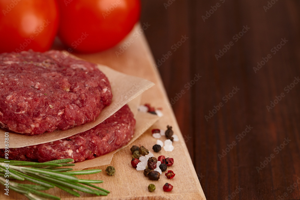 Raw meat beef burger with tomatoes and spices Raw meat beef burger with tomatoes and spices
