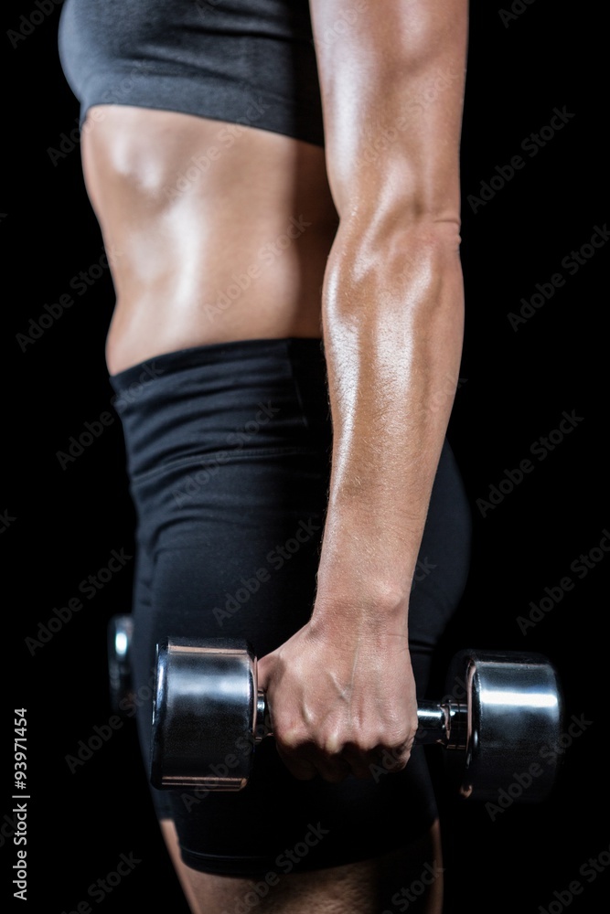 Fototapeta premium Muscular woman lifting heavy dumbbells
