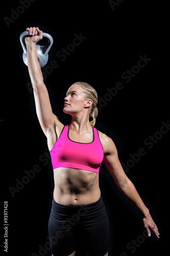 Fototapeta Naklejka Na Ścianę i Meble -  Muscular woman lifting heavy kettlebell