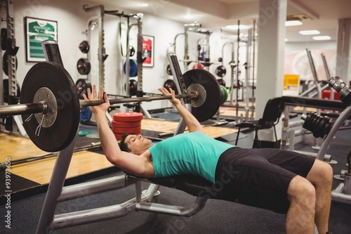 Fit man lifting heavy barbell