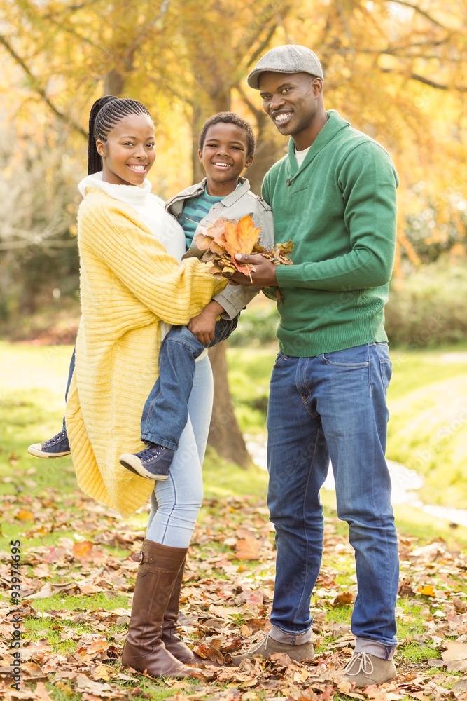 Portrait of a young smiling family holding leaves Portrait of a young smiling family holding leaves