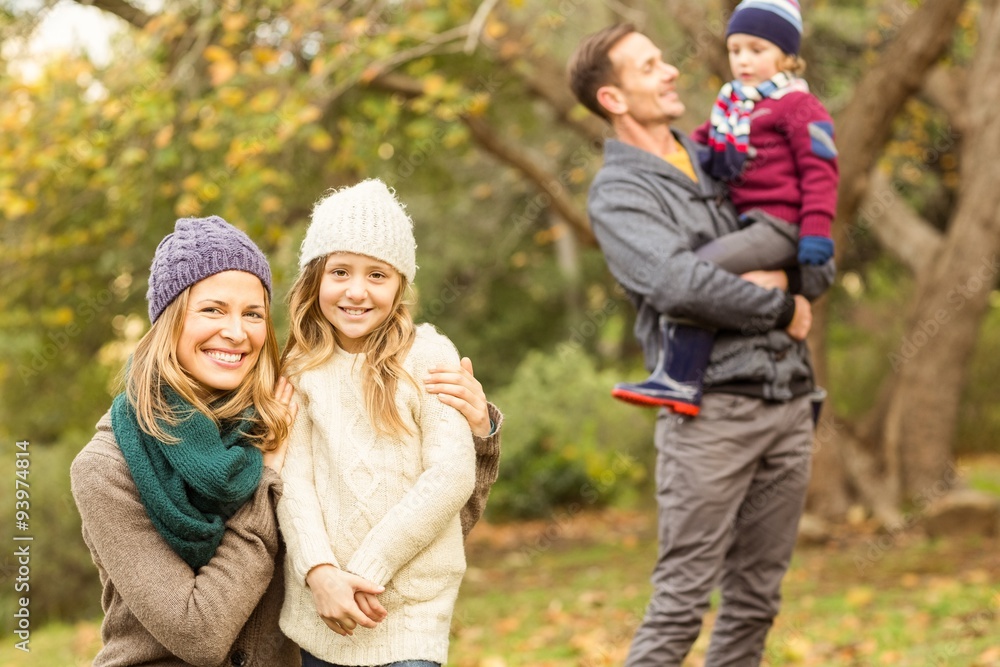 Smiling woman with her daughter against her husband and her son Smiling woman with her daughter against her husband and her son