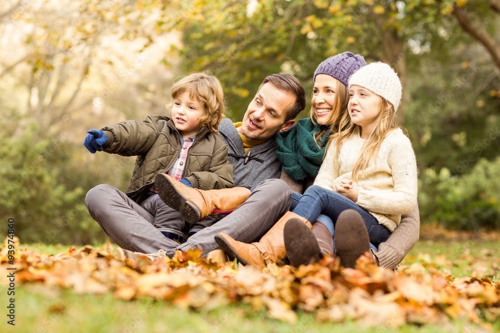 Smiling young family sitting in leaves Smiling young family sitting in leaves