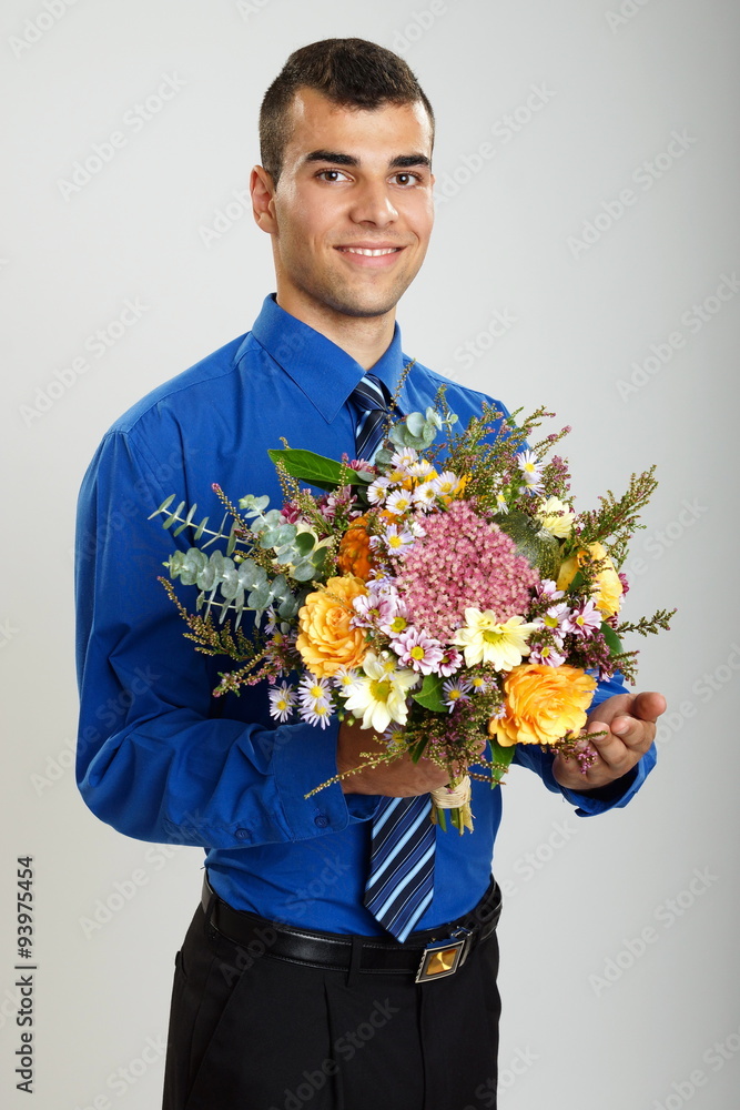 Young smiling man in blue shirt with bouquet of flowers Young smiling man in blue shirt with bouquet of flowers
